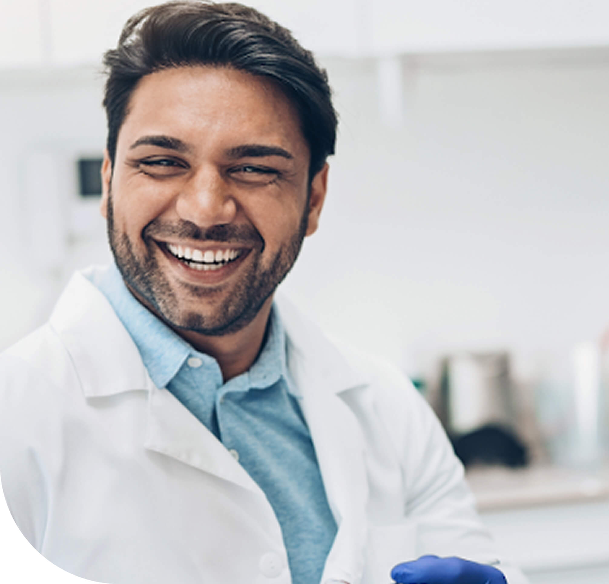 Smiling male scientist in a white lab coat standing in a laboratory